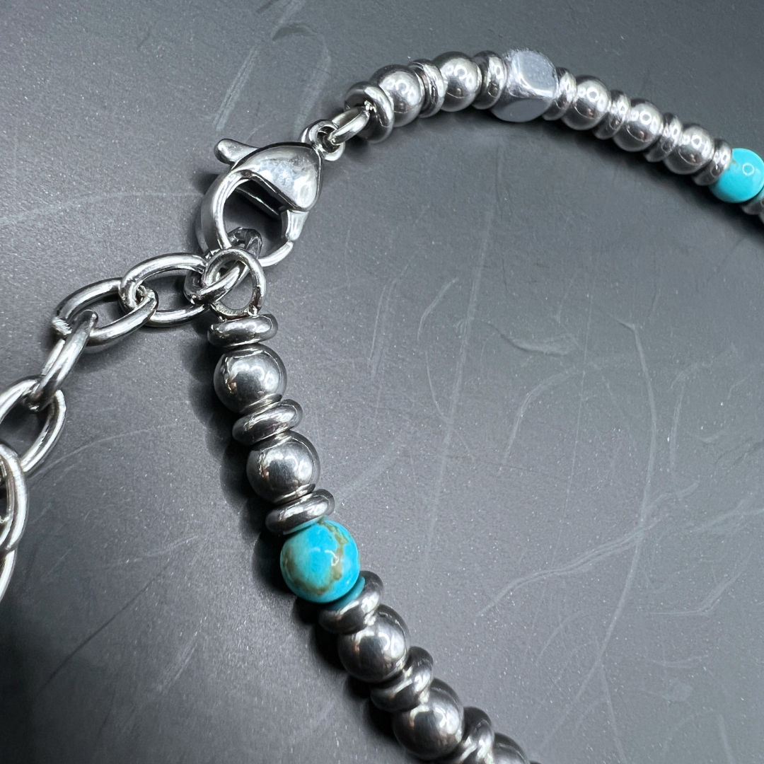 Close-up of Aqua Pulse bracelet lobster clasp and turquoise bead detail on dark background
