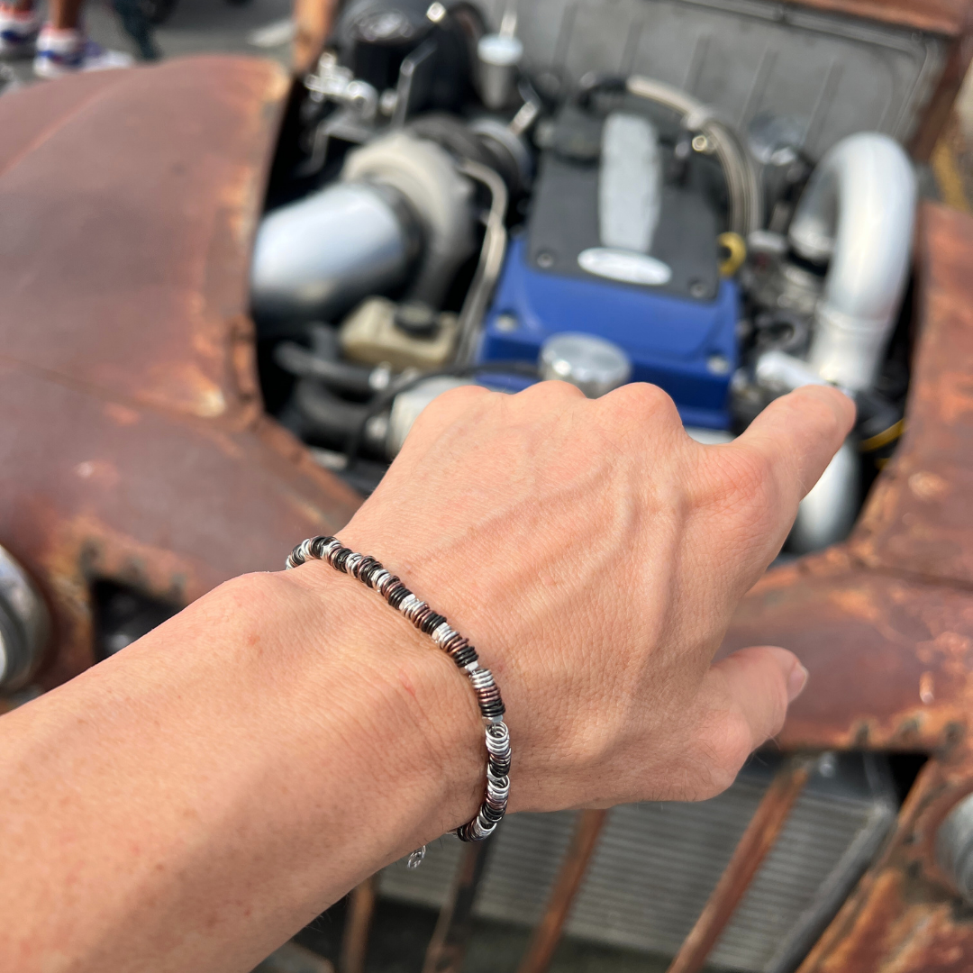 Industrial Torque bracelet variant worn on wrist near classic car engine with exposed turbocharger