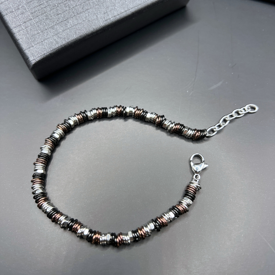 Full flat-lay image of the Industrial Torque bracelet variant on dark background with chain extended