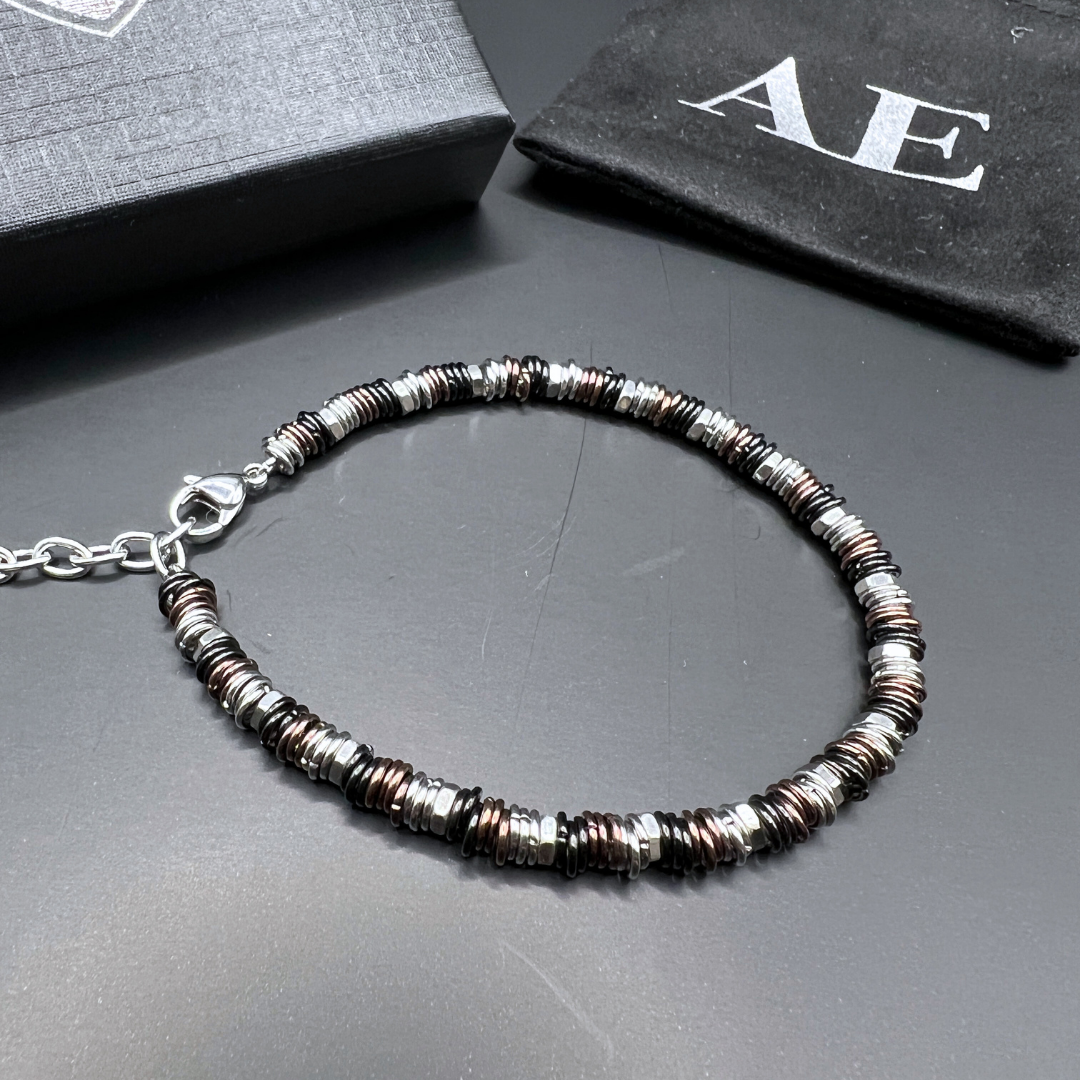 Industrial Torque copper edition bracelet displayed with Armoured Elegance gift box and pouch on black background