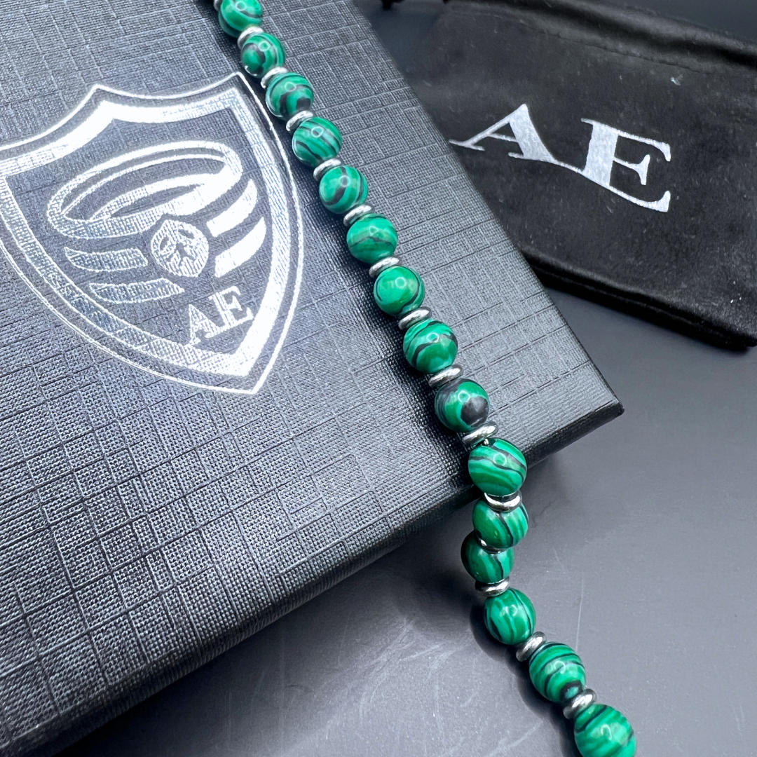 Detail shot of Verdure malachite beads resting on Armoured Elegance gift box