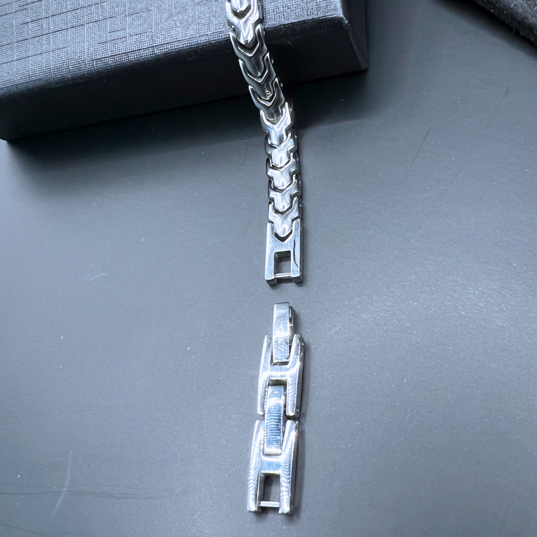 Close-up image of the Aegon bracelet showing additional stainless steel links for adjustability, placed beside the main bracelet.