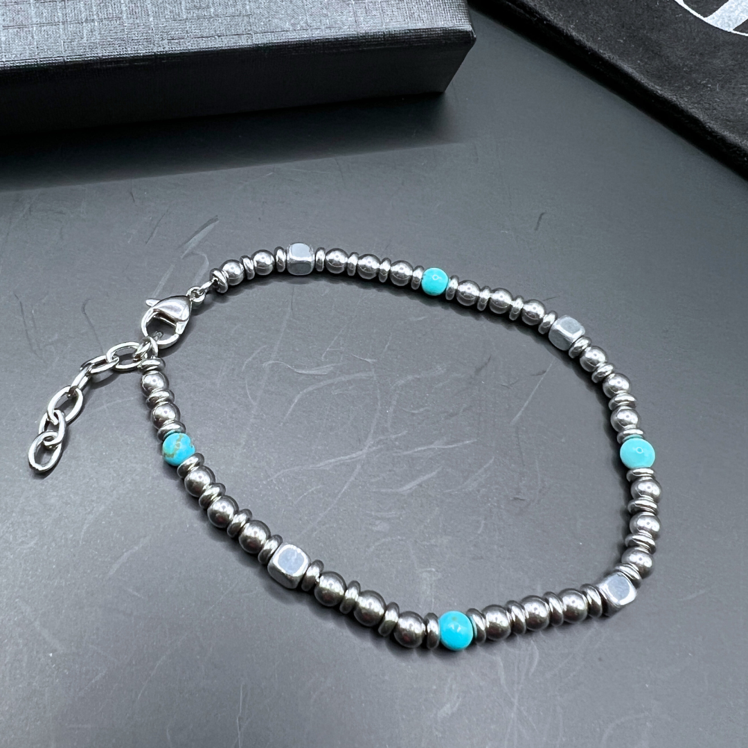 Top view of Aqua Pulse bracelet in a looped shape featuring turquoise beads and stainless steel elements