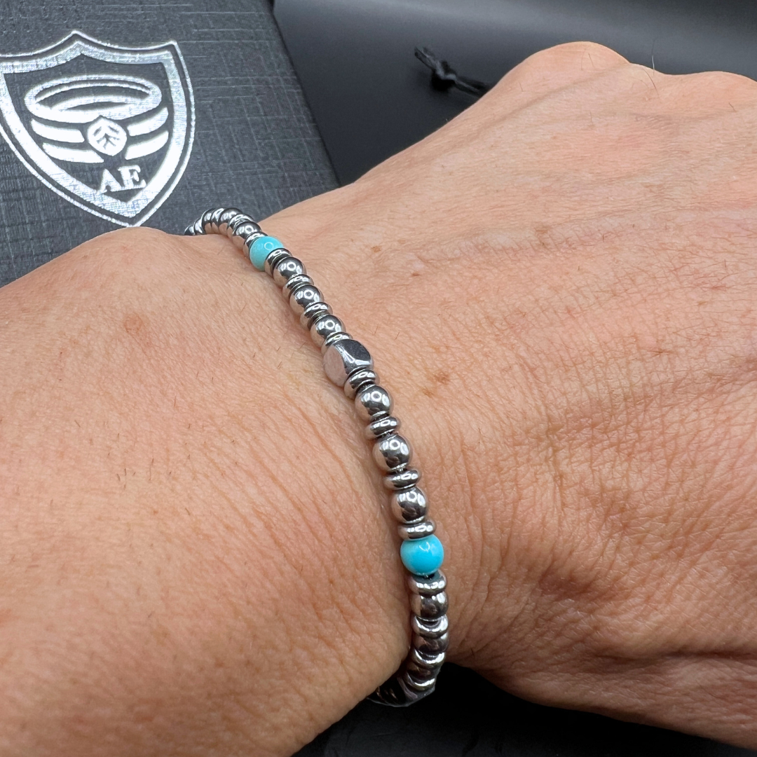 Side view of Aqua Pulse bracelet highlighting turquoise bead between polished stainless steel beads