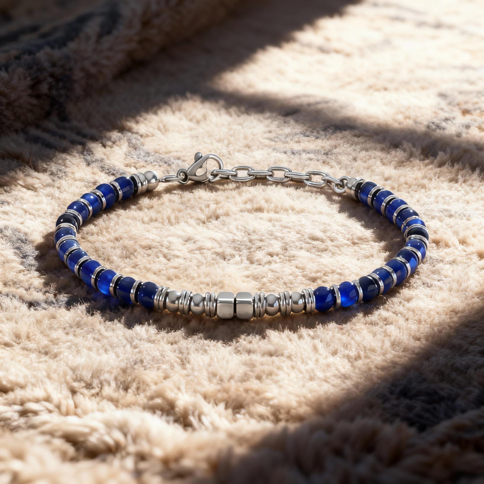 Arctic Luxe bracelet displayed on a soft textured carpet with natural light highlighting the blue stones and stainless steel beads.