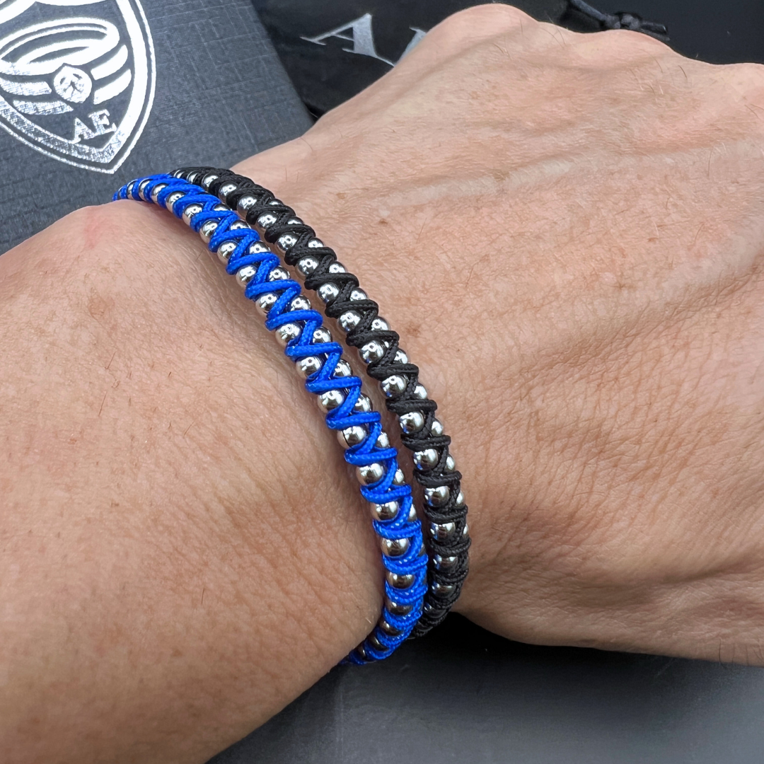 Synergy bracelet stack in blue and black on wrist – stainless steel ball design with woven cord by Armoured Elegance.