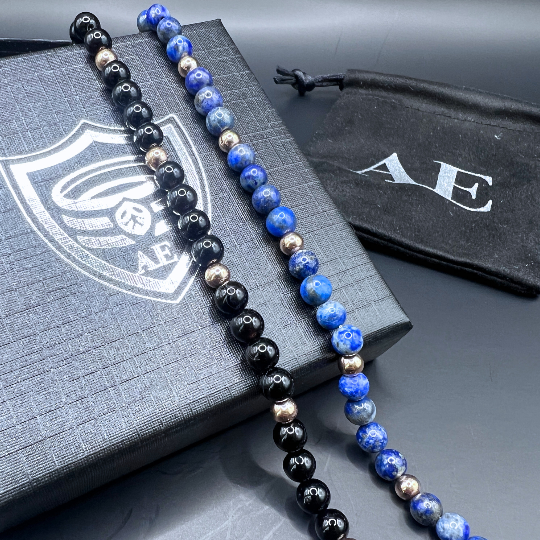 Auric Lineage Shadow and Cosmic bracelets displayed together on Armoured Elegance gift box.