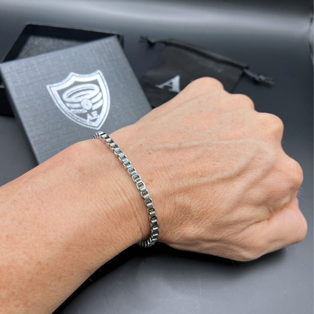 Element stainless steel bracelet on wrist displayed beside Armoured Elegance gift box.