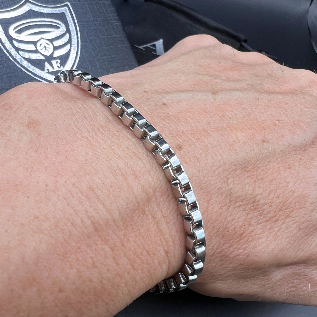 Element stainless steel box-chain bracelet worn on wrist with polished squared links.