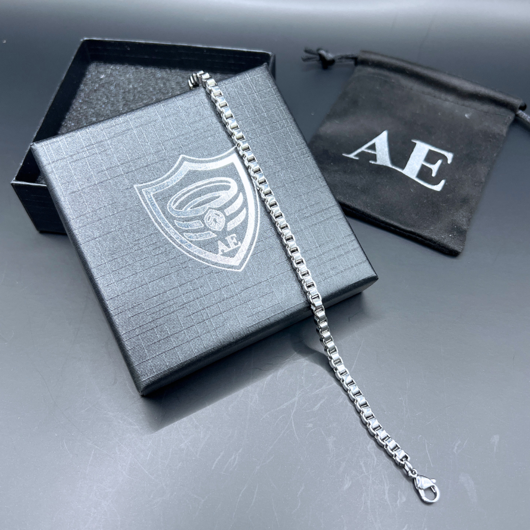 Element stainless steel box-chain bracelet displayed with Armoured Elegance gift box and pouch.