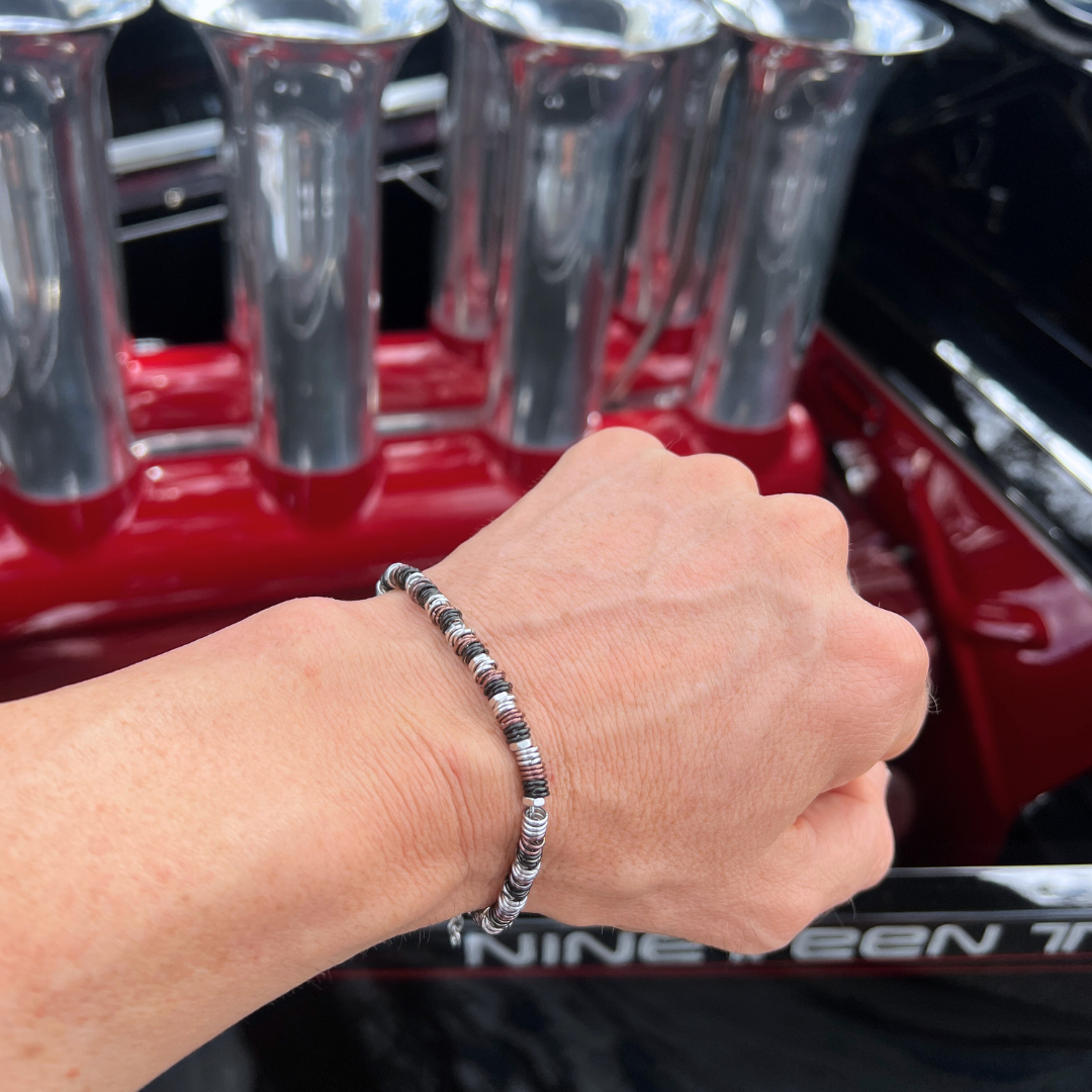 Industrial Torque bracelet variant shown on wrist with polished red car engine backdrop