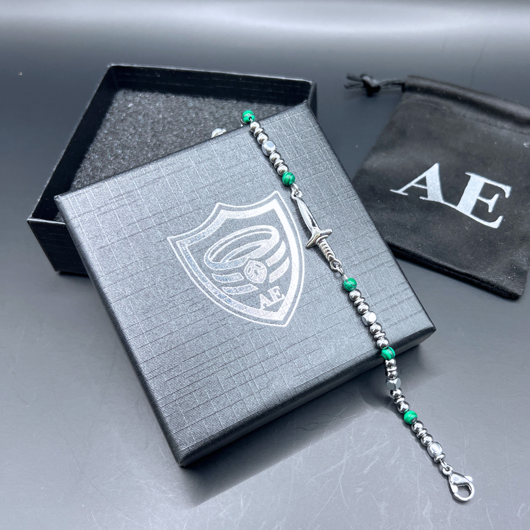 Armoured Elegance Legion bracelet displayed on gift box with stainless steel sword charm and green malachite beads.