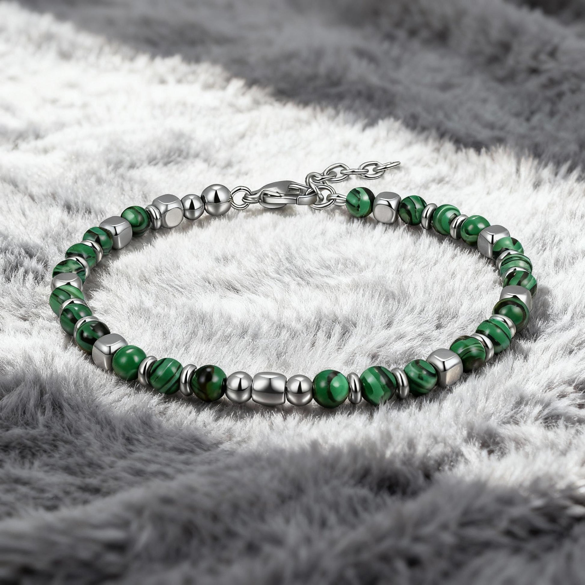 Luxury men’s Malachite Luxe bracelet featuring polished green malachite stones and stainless-steel beads displayed on soft grey fabric background.