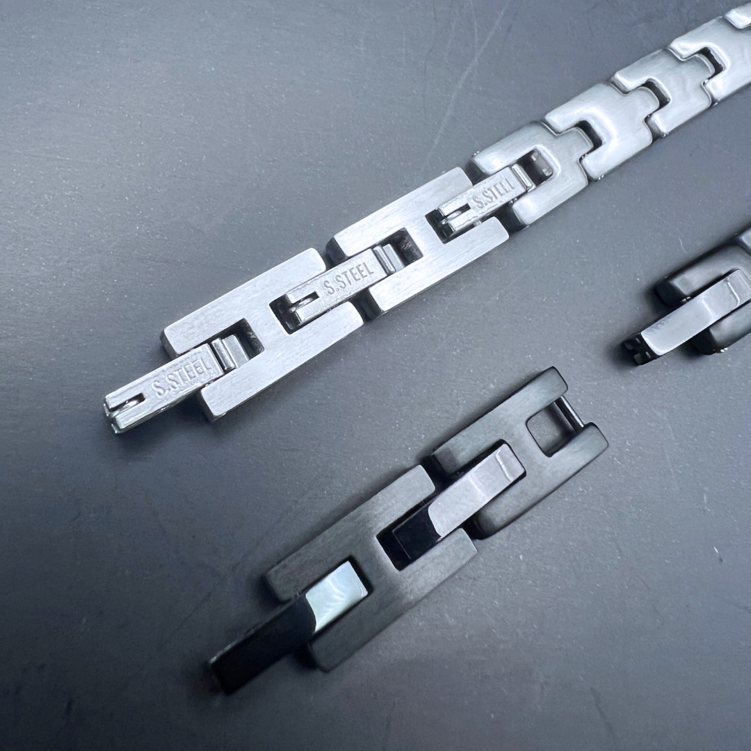 Detailed macro image of Sentinel bracelet stainless steel links in silver and black variants.