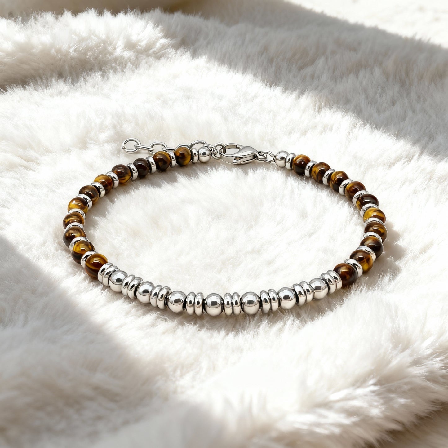 Tiger’s Spirit bracelet resting on soft fabric background, highlighting the natural tiger eye sheen and premium steel craftsmanship.