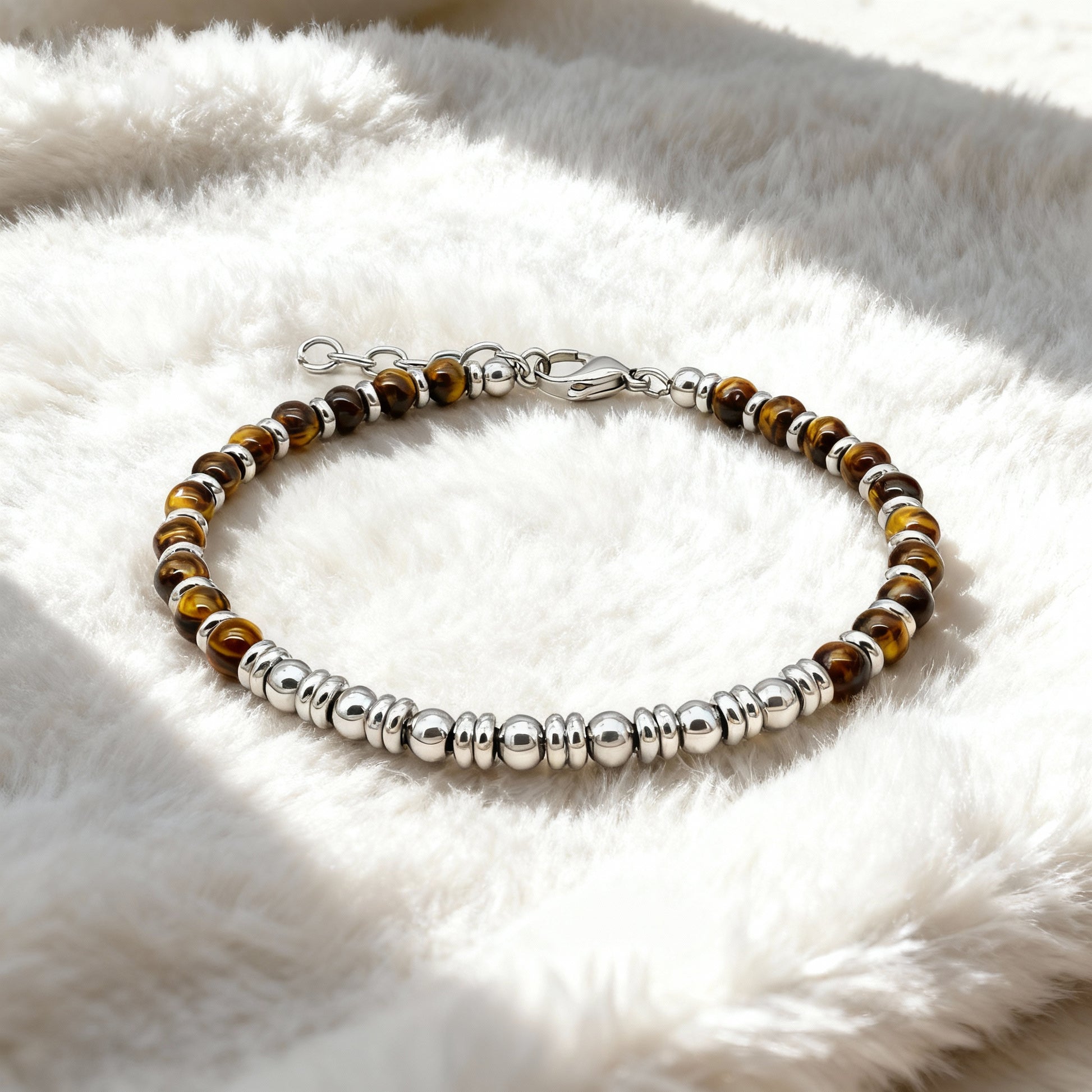 Tiger’s Spirit bracelet resting on soft fabric background, highlighting the natural tiger eye sheen and premium steel craftsmanship.