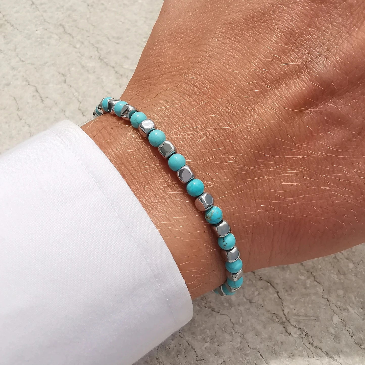 Turquoise Rhythm bracelet worn on wrist, showing slim modern profile and elegant blend of turquoise stones with stainless-steel accents.