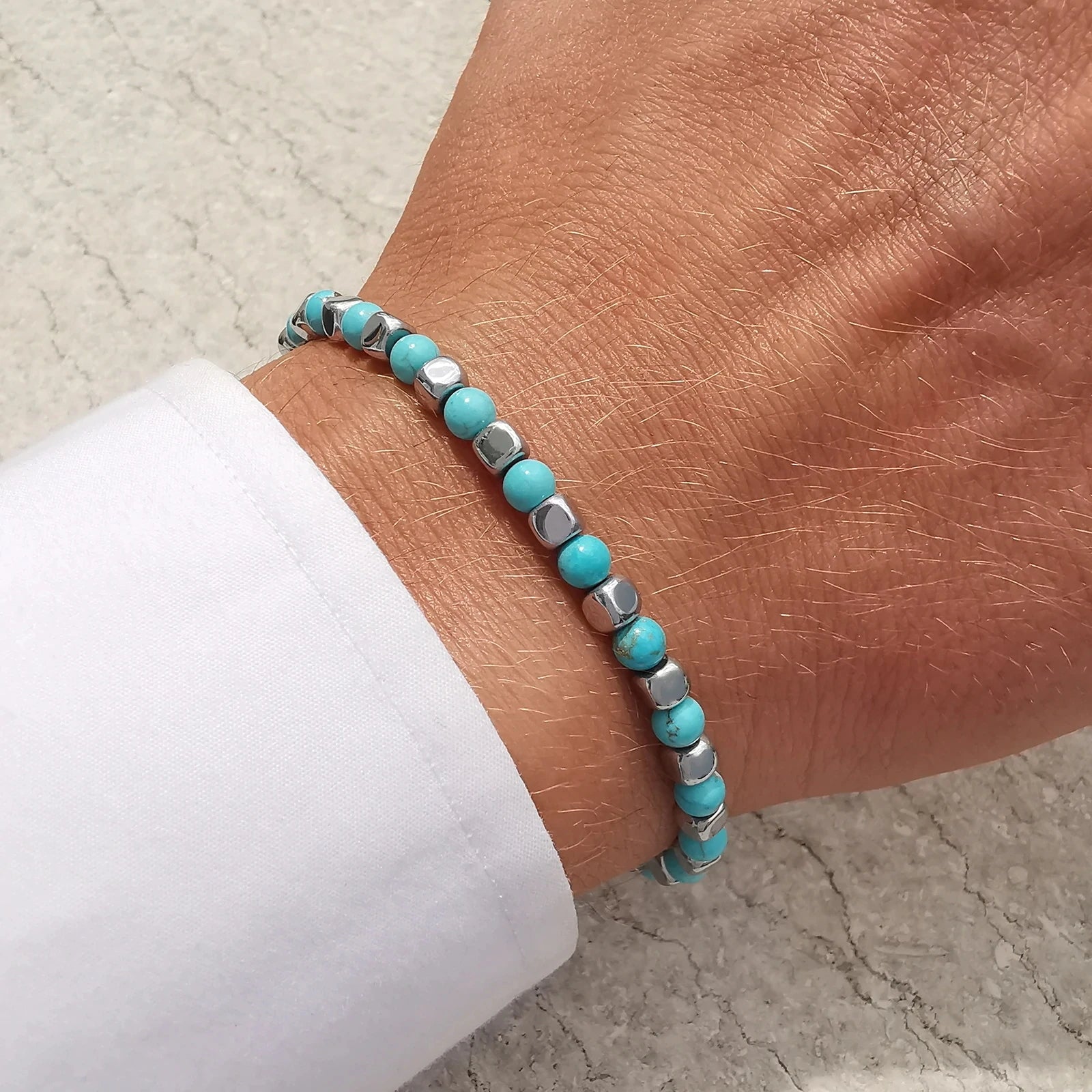 Turquoise Rhythm bracelet worn on wrist, showing slim modern profile and elegant blend of turquoise stones with stainless-steel accents.
