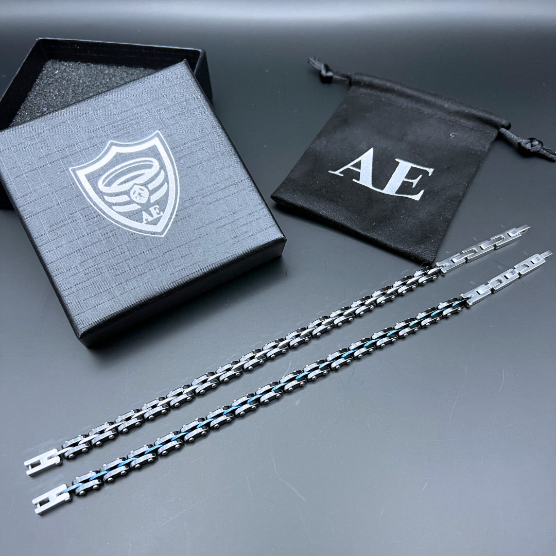 Velocity bracelet in Steel Surge and Blue Surge side by side laid flat with gift box and AE pouch